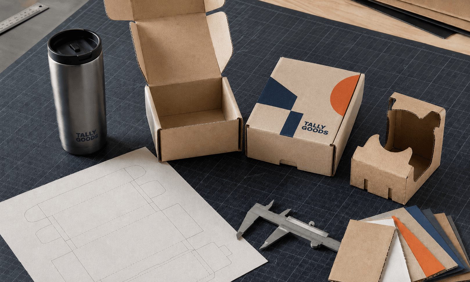 Founder’s packaging development bench with a product, measured prototype, dieline and finished branded boxes.