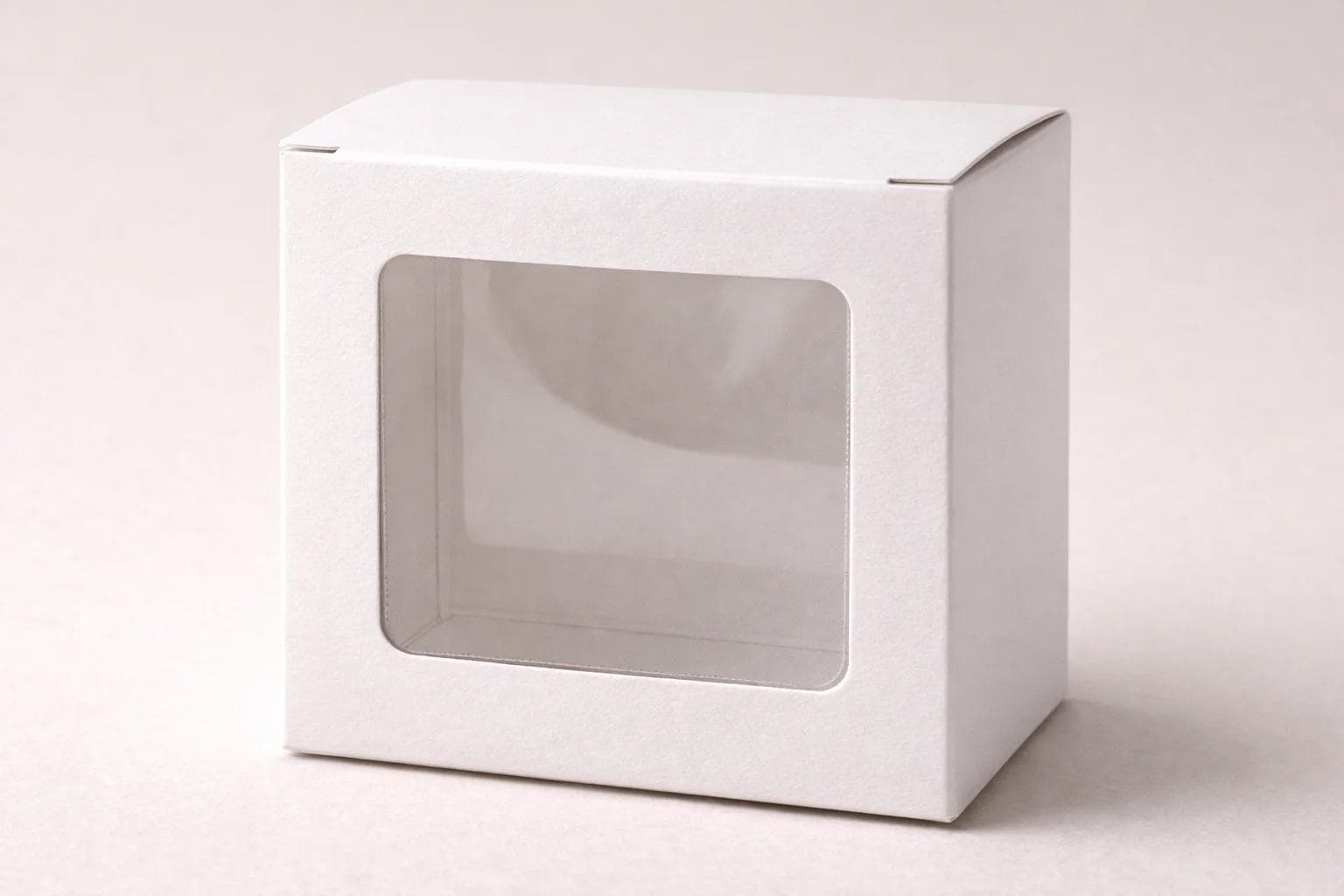 Folding carton with a die-cut window and clear patch film behind the opening